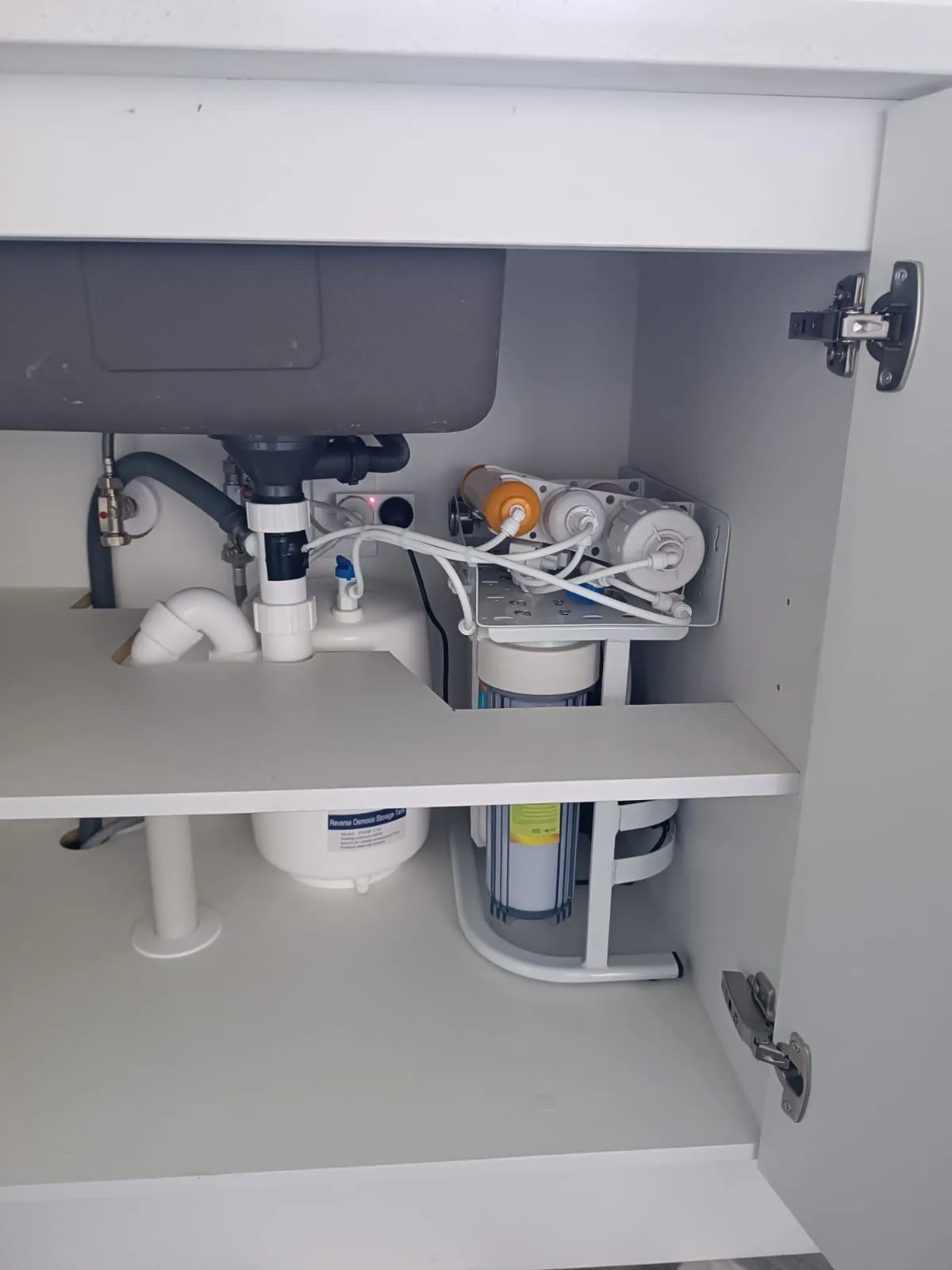 Under bench water filter installed beneath a kitchen sink for a mains water home